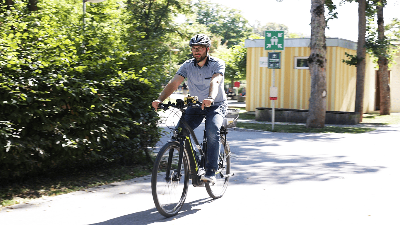 Ein Mann fährt auf einem Fahrrad mit vialytics handy am Lenker und Helm auf dem Kopf