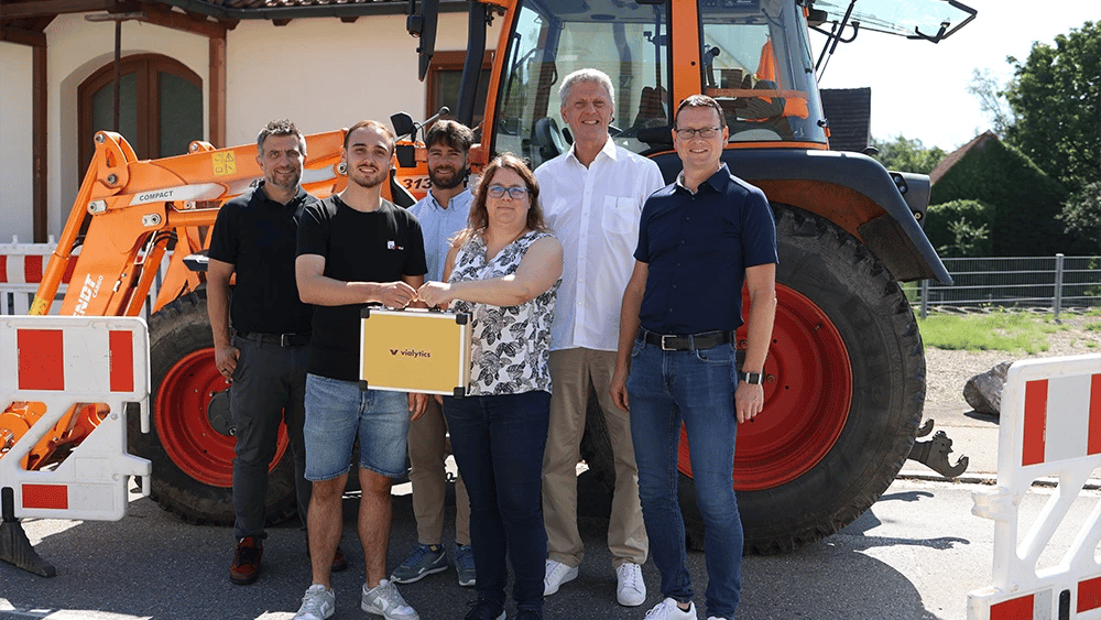 Gruppenbild vor einem Baustellenfahrzeug beim kickoff in Markt Biberbach