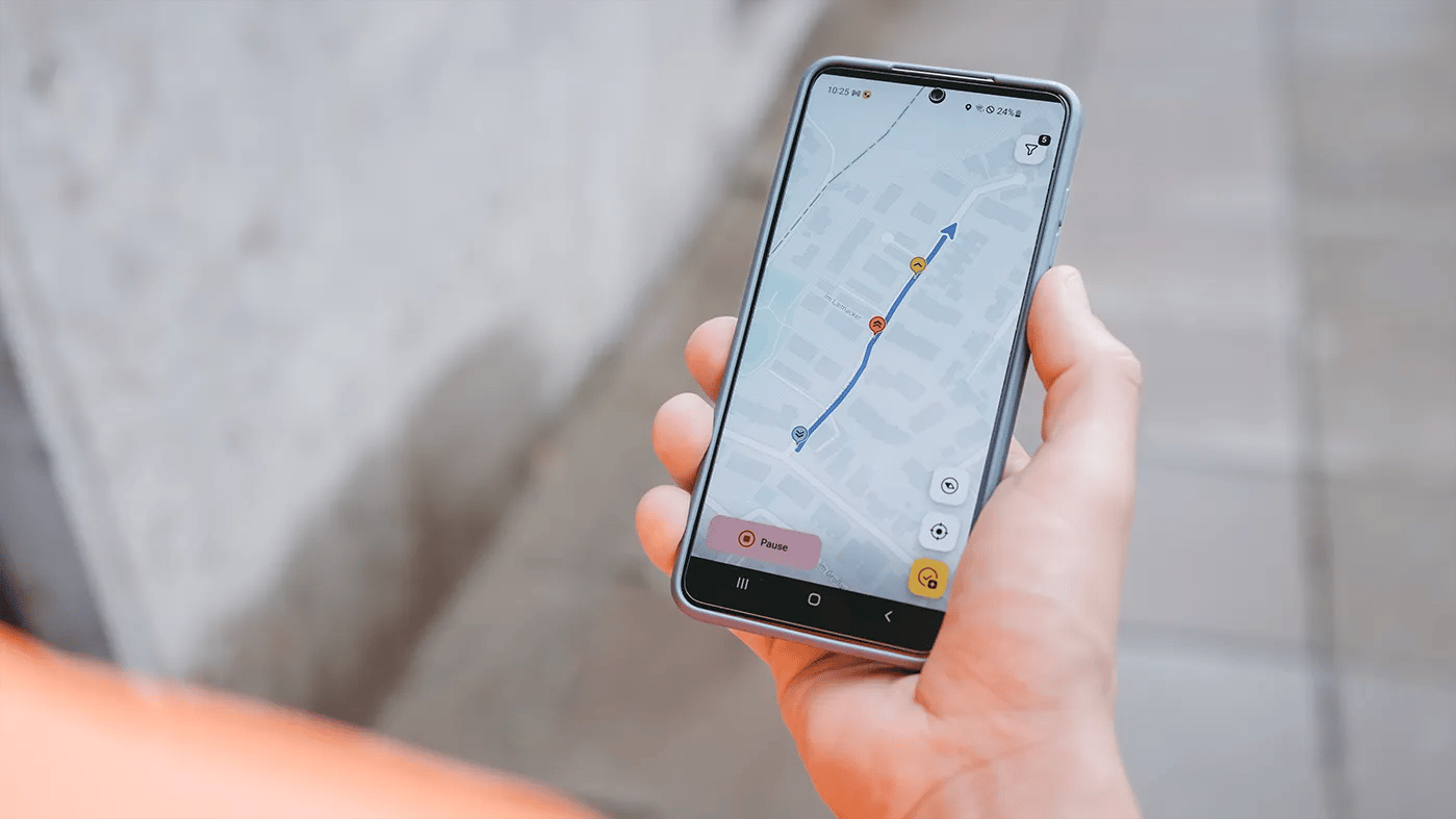 Handy in der Hand mit vialytics ToDo-App und GPS-Spur auf dem Display