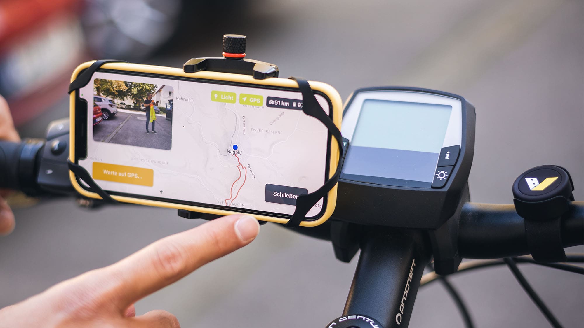 Ein Handy mit der geöffneten Straßenzustandserfassungs-Software montiert an der linken Seite des Lenkrads eines Fahrrads und auf der rechten ist ein Bluetooth Button zur manuellen Zustandserfassung angebracht