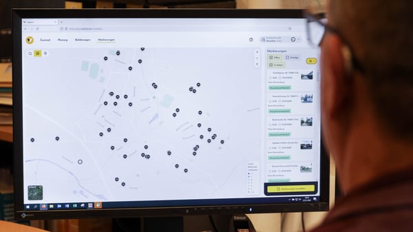 Ein Mann vom Straßenbau sitzt vor dem Web-System von vialytics und schaut sich die markierten Gefahrenstellen an