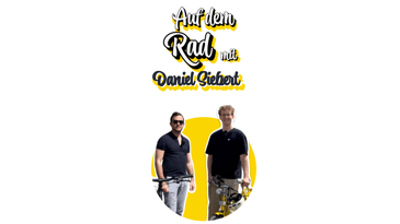 Ein vialytics Mitarbeiter steht, während ein gelbes Fahrrad neben ihm steht, neben Daniel Siebert dem Arbeitskreisleiter der Fahrradwerkstatt der Uni Stuttgart. Im Hintergrund ist ein gelber Kreis und die Überschrift