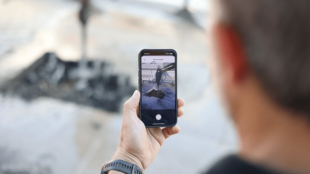 Mann macht ein Foto mit der ToDo-App von einer Aufgrabung und erstellt eine neue Aufgabe