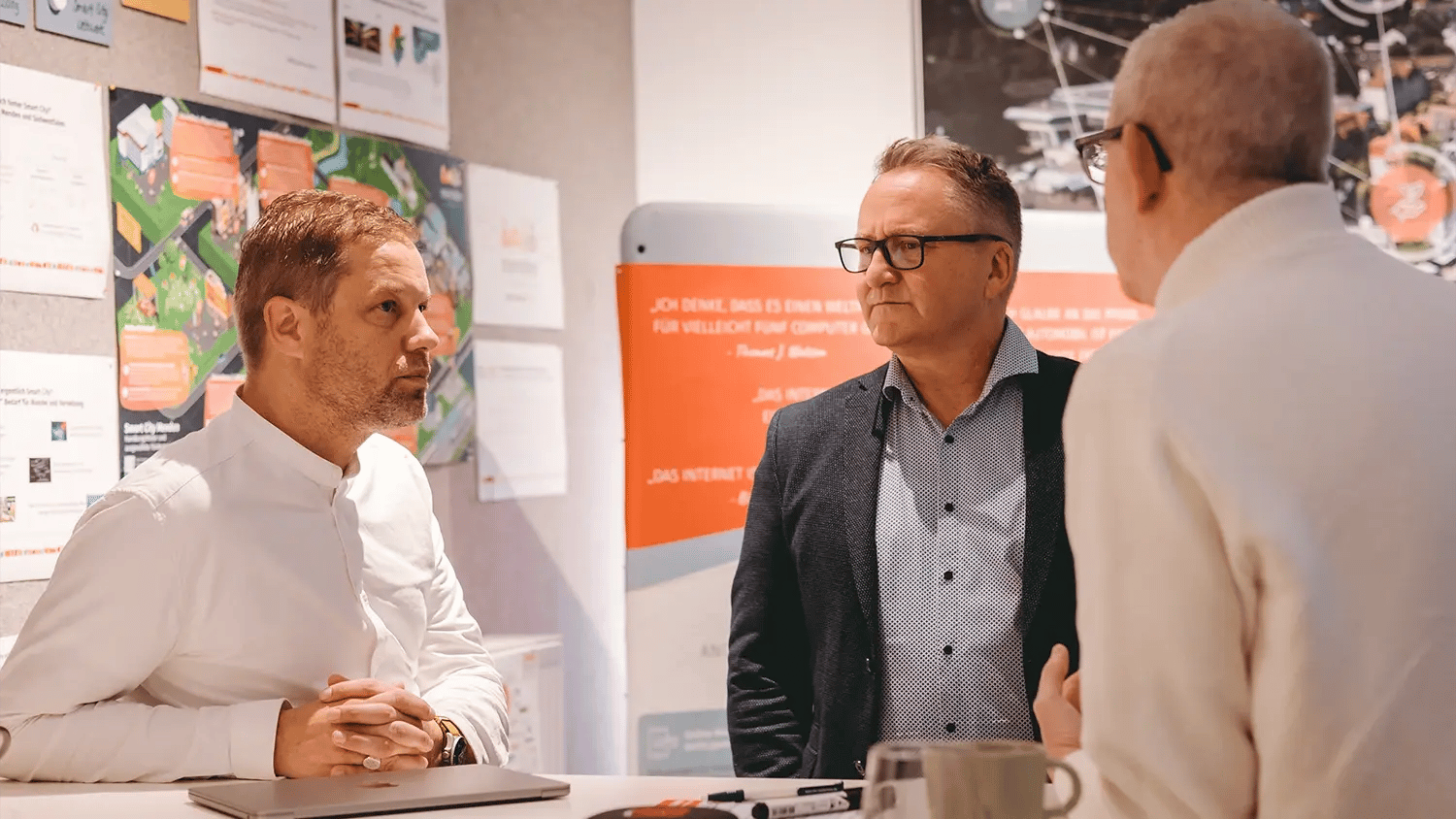 3 männliche Personen unterhalten sich in Menden.