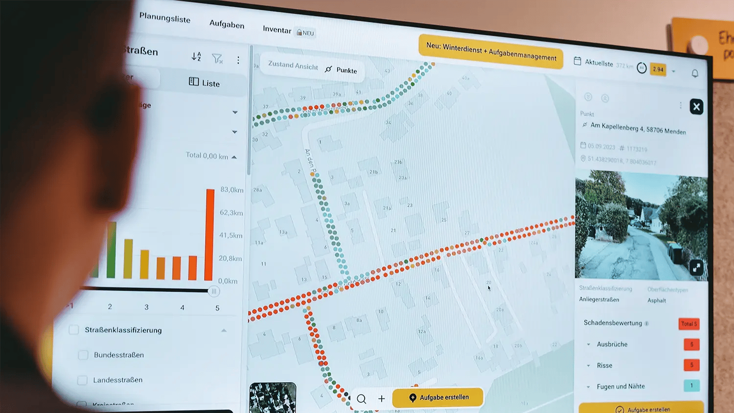 Das Web-System von vialytics wird an einem Monitor von einer Person betrachtet. Es ist eine Kartenansicht zu sehen.