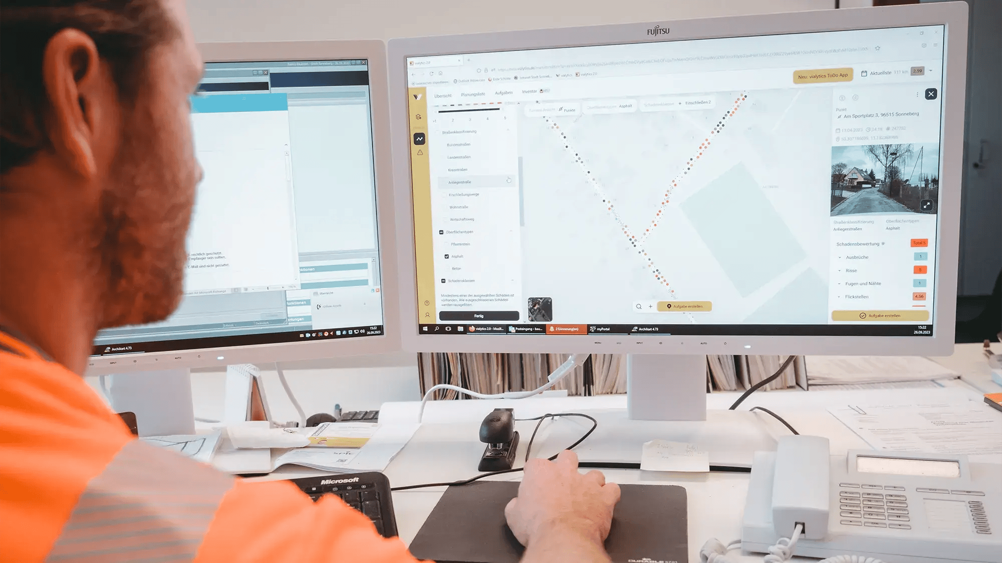 Mann sitzt vor PC und bedient das vialytics Web-System