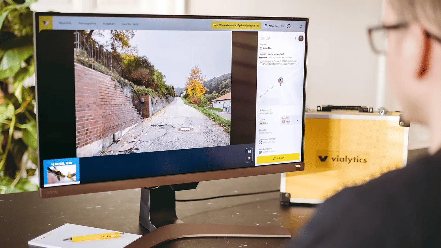 Mann sitzt vor PC und schaut Bilddaten im vialytics Web-System an