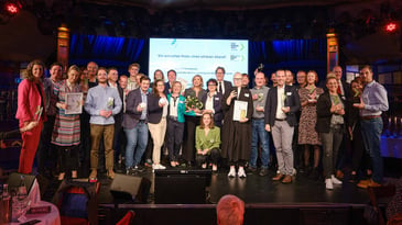 Alle Teilnehmer des KfW Awards stehen mit ihrem Preis in der Hand auf der Bühne für ein großes Gruppenfoto