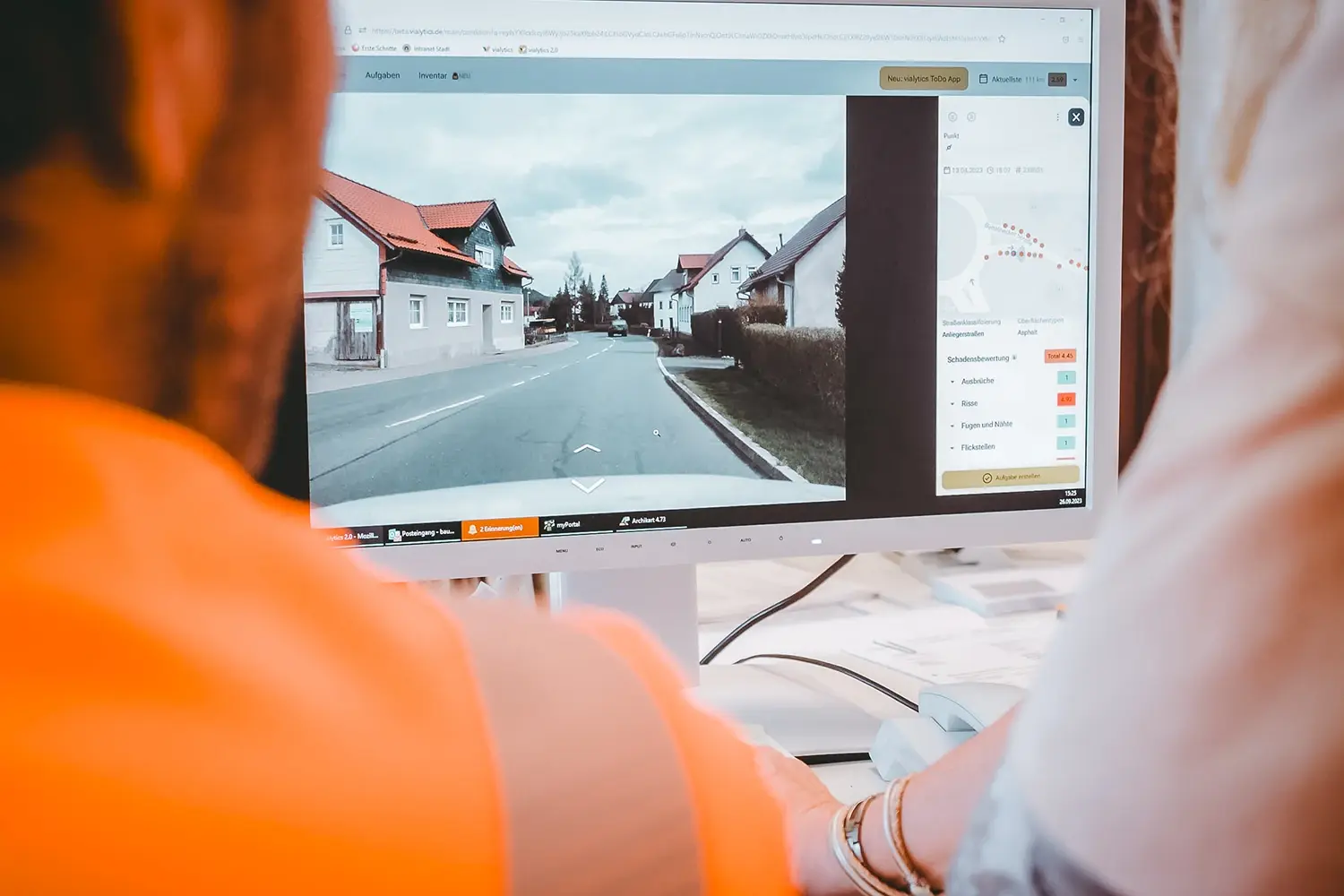Person in oranger Bauhofkleidung vor einem PC mit vialytics Bilddaten