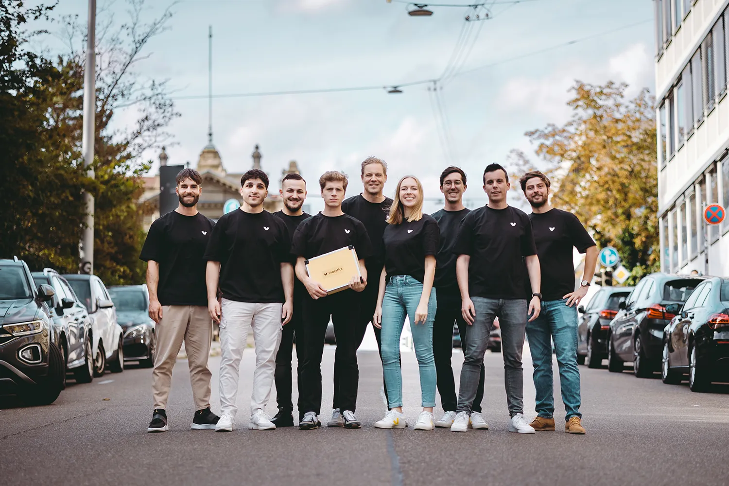 Das vialytics CS Team, mit einem gelben vialytics Koffer auf der Straße